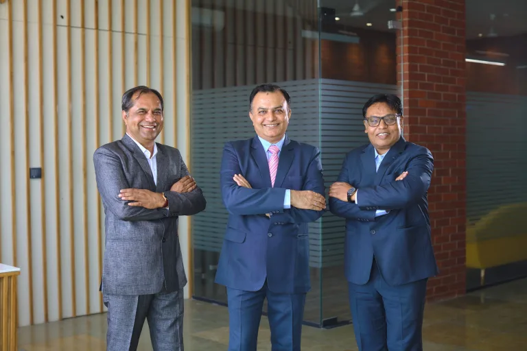 Three members of the Amster Microcell leadership team standing in the office