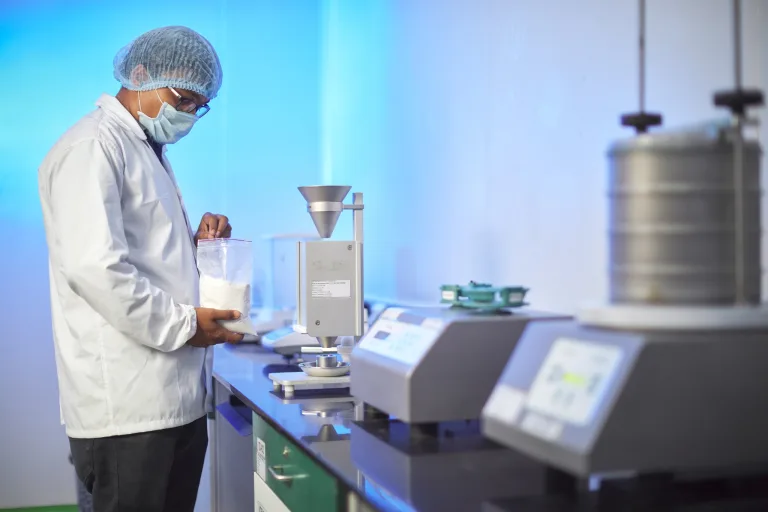 Laboratory technician testing a powder sample on analytical instruments