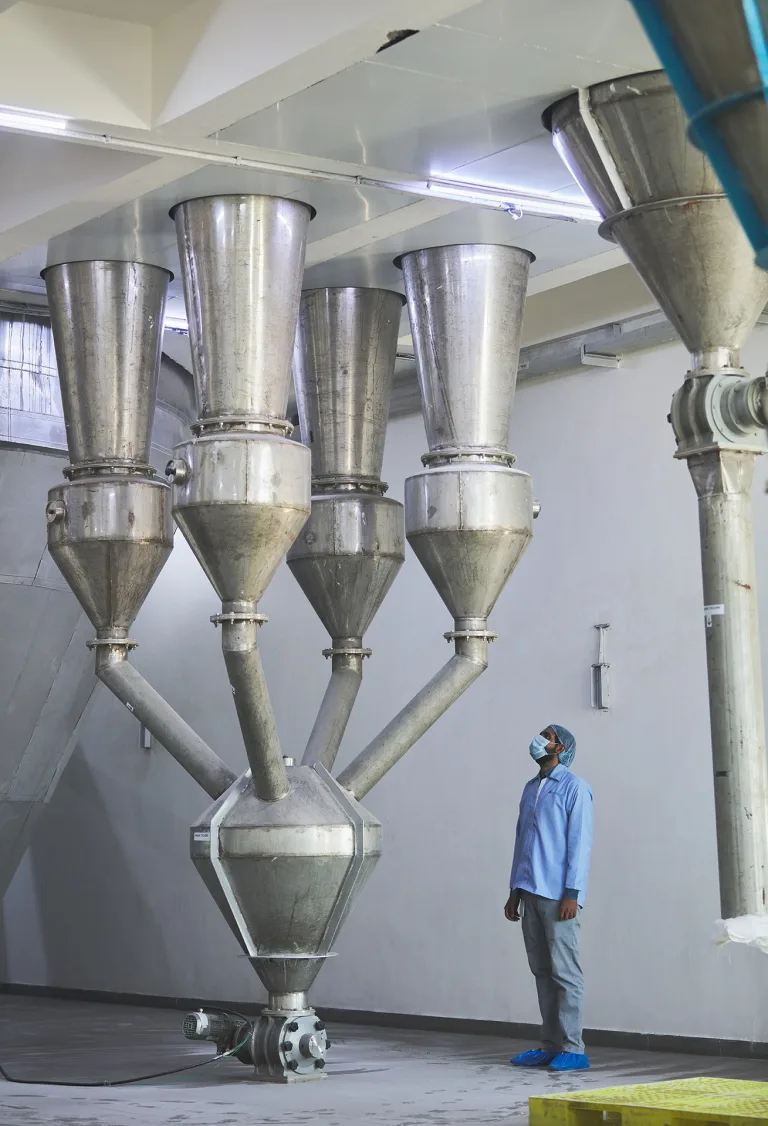The Amster Microcell spray dryer's cyclones, with an operator for scale